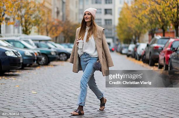 Fashion Blogger and Owner of SCIC Swimwear Sofia Grau holding a coffee to go wearing light blue two tone H&M denim jeans, a pink wool hat &other...