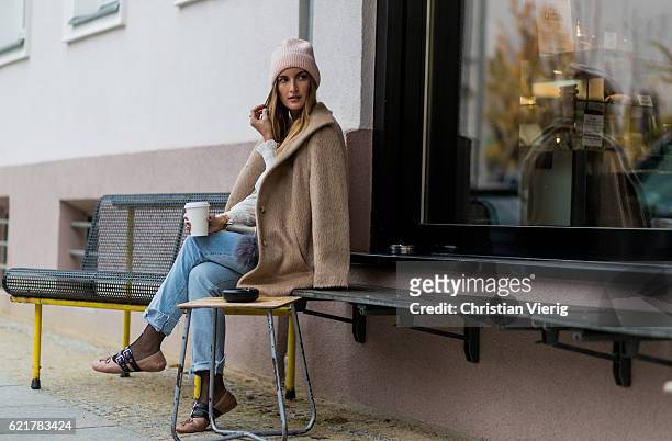 Fashion Blogger and Owner of SCIC Swimwear Sofia Grau holding a coffee to go wearing light blue two tone H&M denim jeans, a pink wool hat &other...