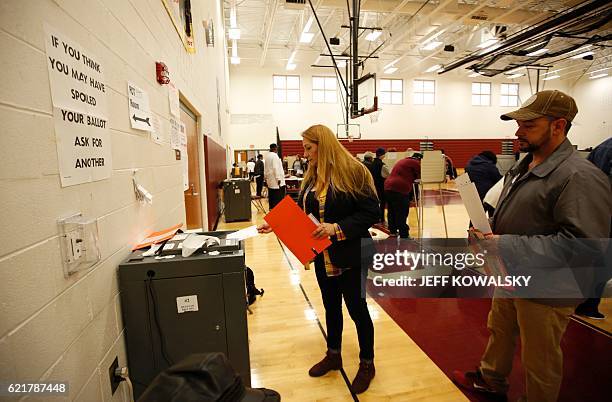 Woman places her ballot in the tabulation machine after voting at Western High School School in the US presidential election on November 8, 2016 in...