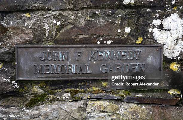 September 2, 2016: A metal plaque and stone pillar mark the entrance to the John F. Kennedy Memorial Garden in Clonakilty, Ireland. Two of the late...