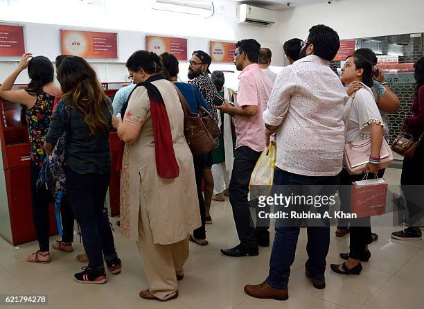 People queue up to use ATM machines after India's Prime Minister Narendra Modi announced the discontinuation of 500 and 1000 Rupee currency notes as...
