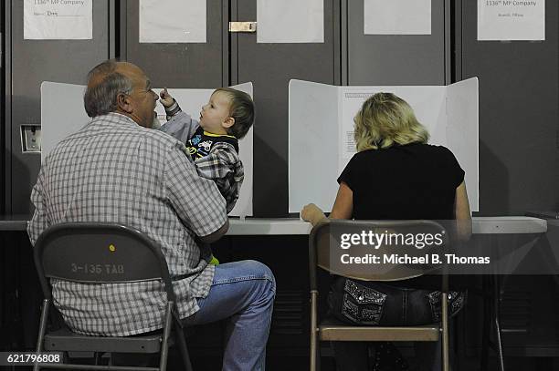 Child plays while voters fill out their ballots at the Missouri National Guard Armory on November 8, 2016 in Lebanon, Missouri. Americans today will...