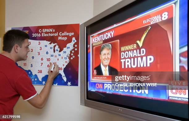 Jake Krupa colors in an electoral map as states are projected for Republican presidential candidate Donald Trump or Democratic Presidential candidate...