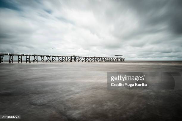 grange jetty in adelaide under a cloudy sky - bay adelaide stock pictures, royalty-free photos & images