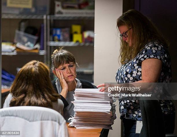 Johanna Stiles and Dana McBride prepare to open one of several stacks of vote-by-mail ballots to present to the Leon County, Florida Canvassing Board...