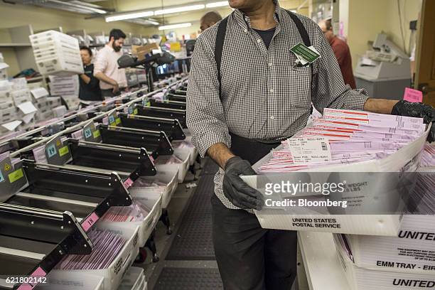 An official holds a box containing mail-in-ballots at the San Francisco City Hall polling location in San Francisco, California, U.S., on Tuesday,...