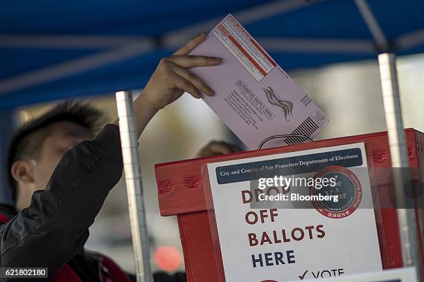 An official puts a mail-in ballot into a box at the San Francisco City Hall polling location in San Francisco, California, U.S., on Tuesday, Nov. 8,...