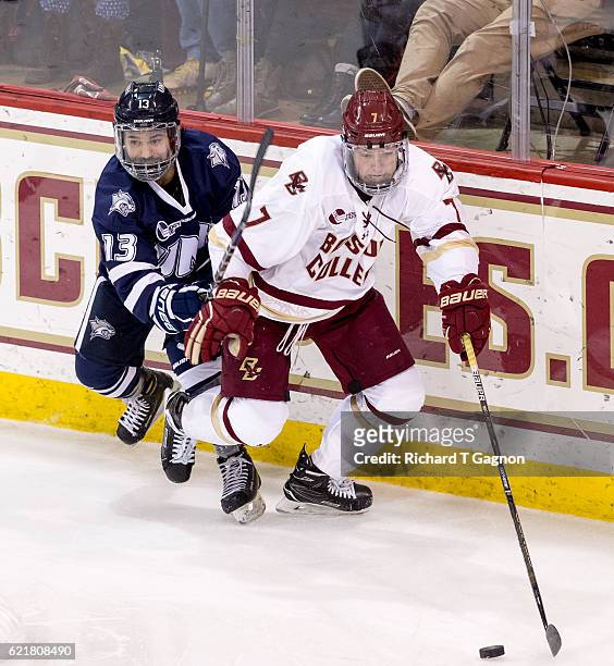 Connor Moore of the Boston College Eagles controls the puck away from Justin Fregona of the New Hampshire Wildcats during NCAA hockey at Kelley Rink...