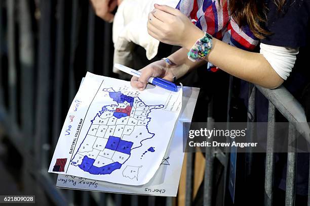 Woman holds an electoral map as voting results come in at Democratic presidential nominee former Secretary of State Hillary Clinton's election night...