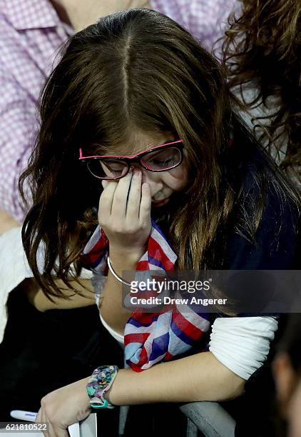 Young girl rubs her eyes as she watches voting results come in at Democratic presidential nominee former Secretary of State Hillary Clinton's...