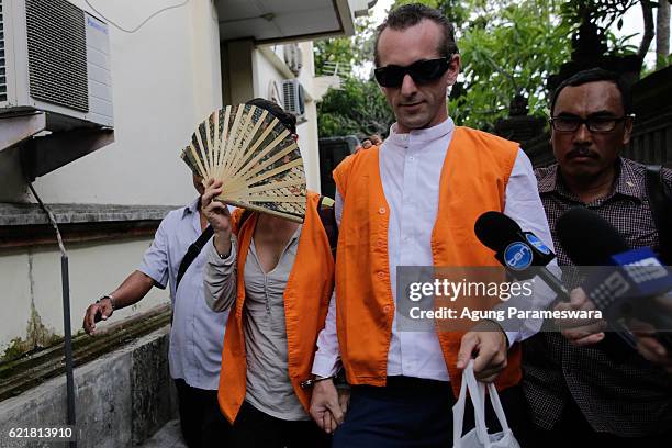 Australian Sarah Connor who covers her face with fans and British David taylor walk as they arrive at Denpasar Court for their first trial on...