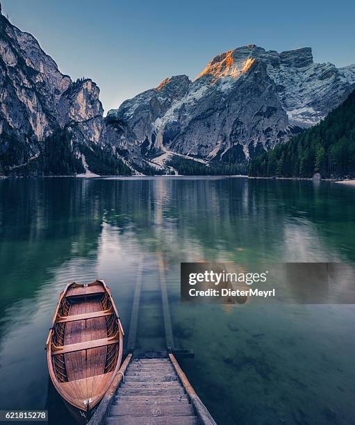 lone boat at sunrise at unesco world heritage lake braies - pragser wildsee stock pictures, royalty-free photos & images