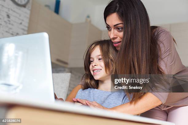 nettes mädchen und mutter mit laptop zu hause - parental control stock-fotos und bilder