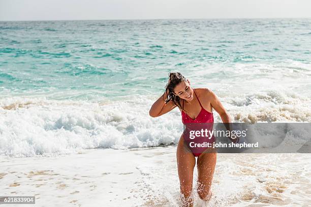 mujer feliz caminando fuera del mar. - traje de baño fotografías e imágenes de stock