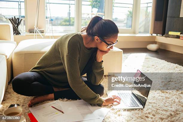 young woman studying and working on her laptop - money floor stock pictures, royalty-free photos & images