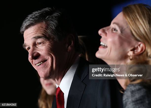 Democratic gubernatorial candidate Roy Cooper and his wife Kristin Cooper, right, along with family, relish in Cooper's claimed victory over...