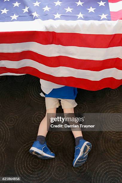 Young boy plays under a table during a 'Democrats Abroad' function at the Kingston Hotel during on November 9, 2016 in Melbourne, Australia....