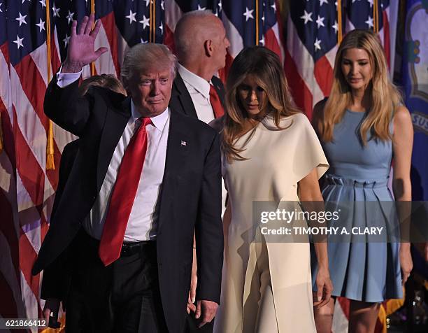 Republican presidential candidate Donald Trump flanked by his wife Melania and members of his family waves after speaking to supporters during...
