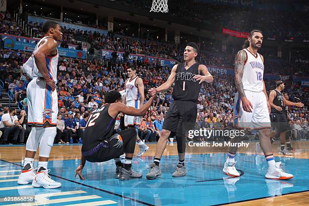 Devin Booker helps up TJ Warren of the Phoenix Suns before the gameb against the Oklahoma City Thunder on October 28, 2016 at the Chesapeake Energy...