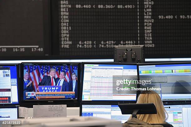 Trader works at the Frankfurt Stock Exchange while Donald Trump is seen on a monitor in the background on November 9, 2016 in Frankfurt, Germany....
