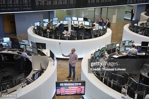 Journalist takes a picture of the graph showing the day's course of the DAX index at the Frankfurt Stock Exchange while a TV monitor with the...