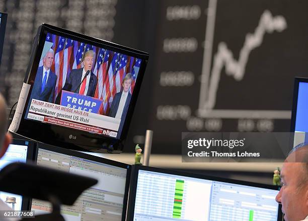 Donald Trump is seen on a TV screen below the graph showing the day's course of the DAX index at the Frankfurt Stock Exchange on November 9, 2016 in...