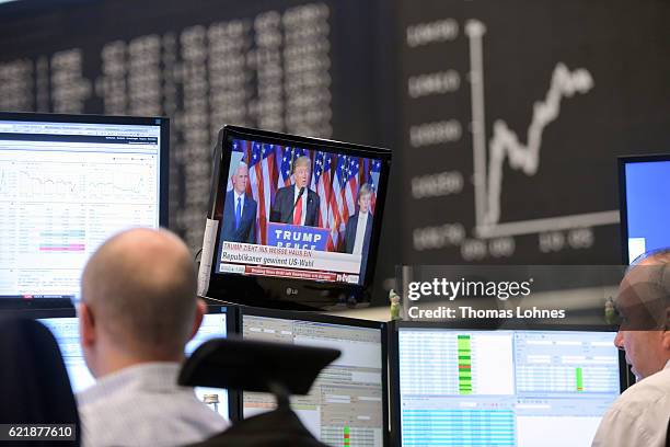 Donald Trump is seen on a TV screen below the graph showing the day's course of the DAX index at the Frankfurt Stock Exchange on November 9, 2016 in...