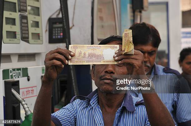 Petrol Pump worker look on Indian Currency 500 Rupees , HP PETROL PUMP dealers not to accept Rs. 500 and 1000 Indian currency, A close-up view of a...