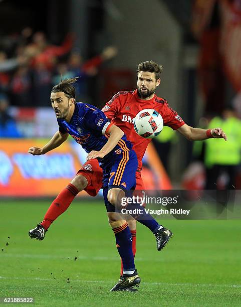 Allen of New York City FC is tackled by Drew Moor of Toronto FC during the first half of an MLS Conference semi-final playoff game at BMO Field on...