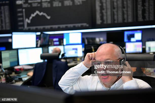 Trader works below the graph showing the day's course of the DAX index at the Frankfurt Stock Exchange on November 9, 2016 in Frankfurt, Germany....