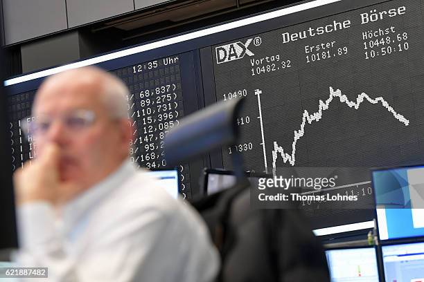Trader works below the graph showing the day's course of the DAX index at the Frankfurt Stock Exchange on November 9, 2016 in Frankfurt, Germany....