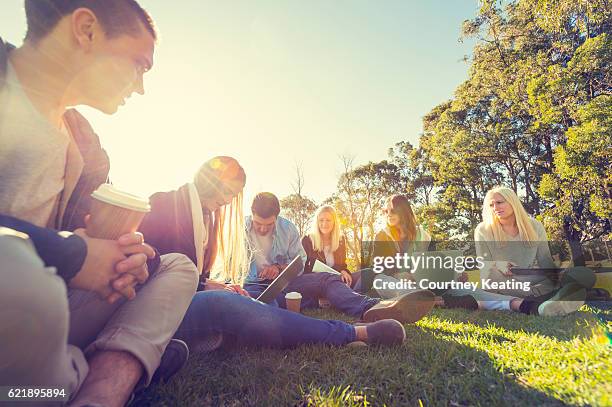 gruppe von jugendlichen mit technologie - park relaxing stock-fotos und bilder