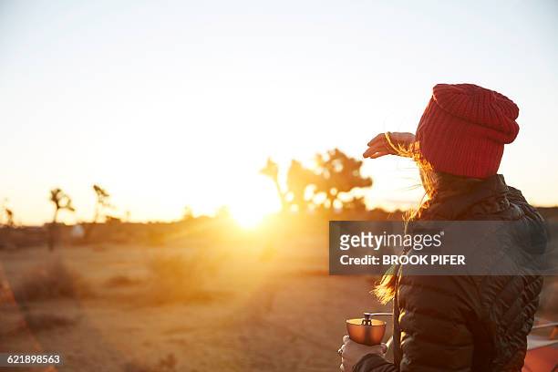 young woman taking in sunrise at campsite - brook steppe photos et images de collection
