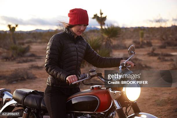 young woman riding motorcycle on empty road - brook steppe photos et images de collection