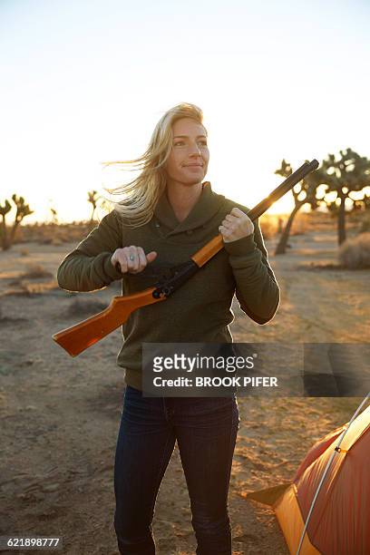 young woman shooting bb gun at campsite - brook steppe photos et images de collection