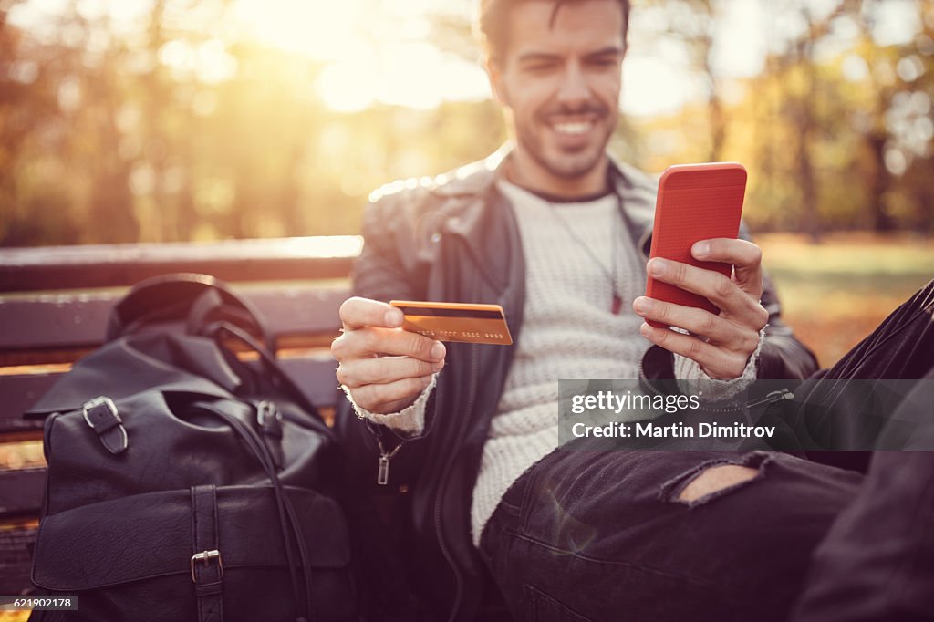 Jeune homme effectuant un paiement par carte de crédit en ligne