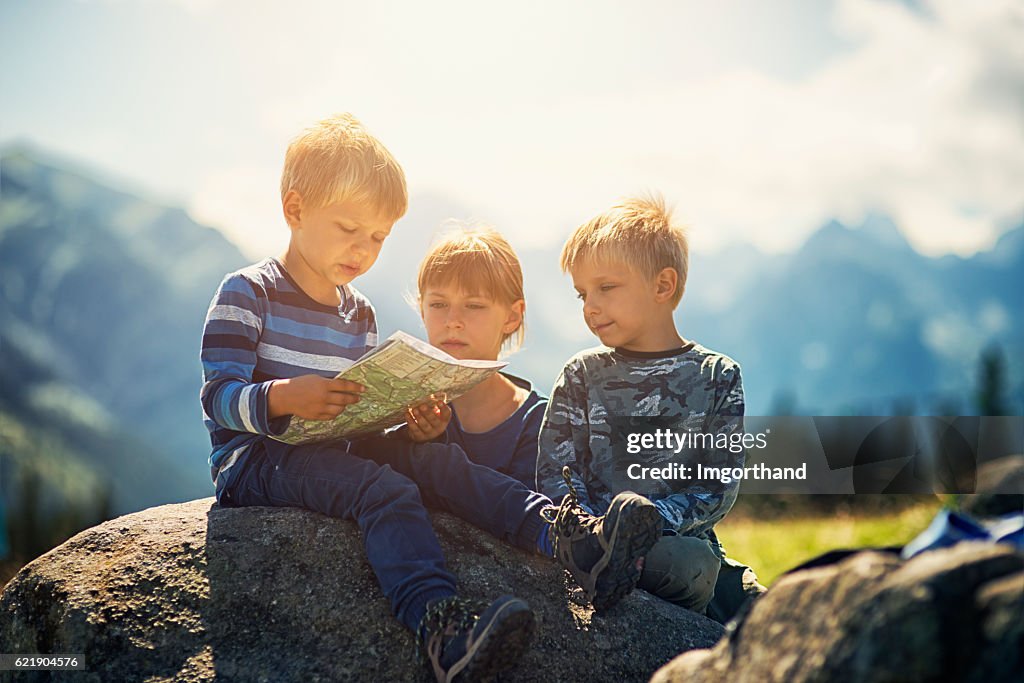 Little hikers checking map in mountains