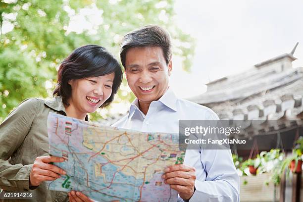 senior couple tourists looking at map - tourist map stock pictures, royalty-free photos & images