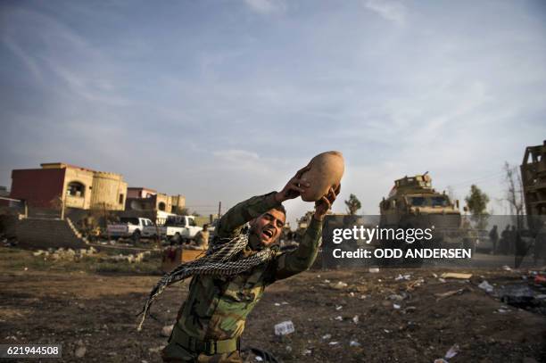 An Iraqi Kurdish Peshmerga fighter catches a ball as he plays with comrades after returning from combat against Islamic State group jihadists in...