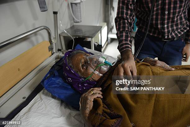 An Indian medical personnel treats the victim of a ammonia leak in the Intensive Care Unit of the Sola Civil Hospital in Ahmedabad on November 9,...