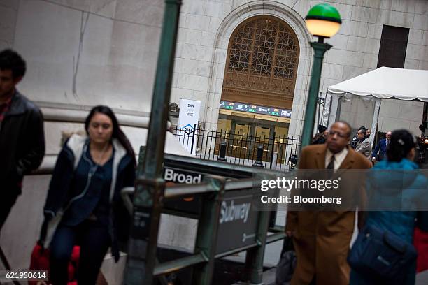 Pedestrians walk in front of the New York Stock Exchange in New York, U.S., on Wednesday, Nov. 9, 2016. U.S. Stocks fluctuated in volatile trading in...