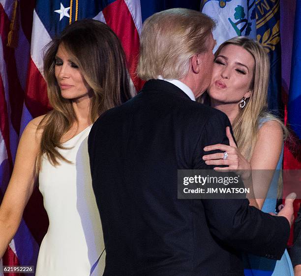 Republican presidential elect Donald Trump kisses his daughter Ivanka Trump as his wife Melania Trump looks on after speaking during election night...