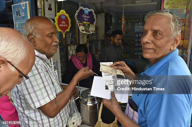 Man giving the photo-copy of Aadhar Card along with Rs. 1000 at a Mother Dairy milk booth in Mayur Vihar on November 9, 2016 in New Delhi, India. In...