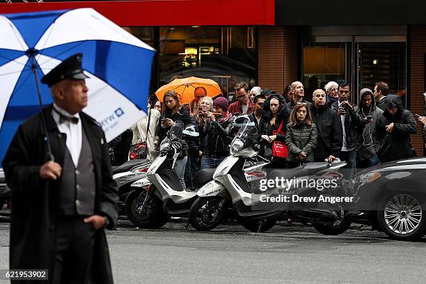 Onlookers gather and wait for the arrival of Hillary Clinton outside of the New Yorker Hotel, November 9, 2016 in New York City. Clinton planned to...