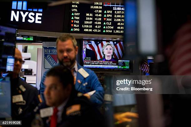 Hillary Clinton, former 2016 Democratic presidential nominee, is seen speaking on a television while traders work on the floor of the New York Stock...