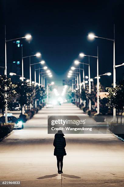 woman stands in centre of the road, donghai. - straßenlaterne stock-fotos und bilder