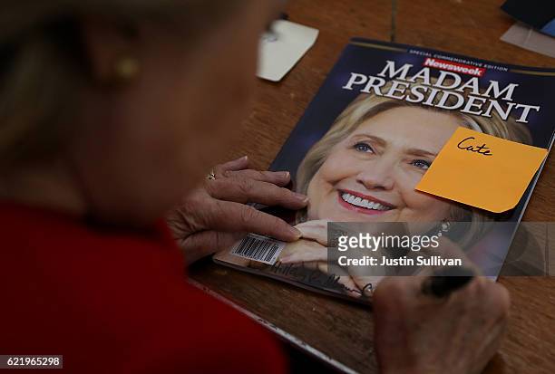 Democratic presidential nominee former Secretary of State Hillary Clinton signs an autograph on a Newsweek 'Madam President' commemerative magazine...