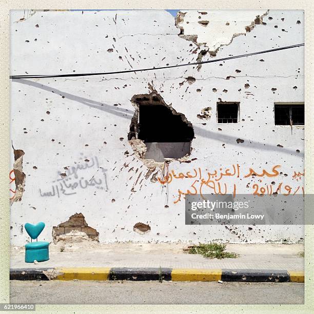 Heart shaped chair sits beside a bullet and mortar scarred wall along the City's infamous Tripoli street, the front line during the bloody siege of...