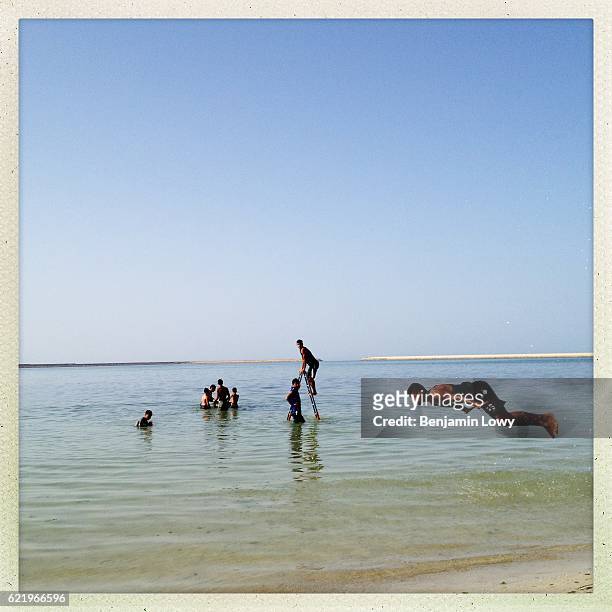 Young Libyan men jump into the sea from a family beach on July 12, 2012 in Tripoli. Libya.