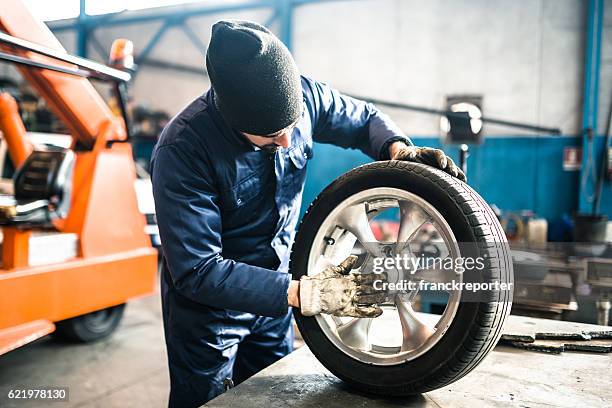 tire repairer checking the tire integrity - clean garage stock pictures, royalty-free photos & images